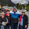 NZL WTC FranzJosef 2018APR30 MainStreet 002  Did we try and help or dissuade her of such a foolish activity???   Nope, not a chance ..... we took our own group photos in the same spot!!! : - DATE, - PLACES, - TRIPS, 10's, 2018, 2018 - Kiwi Kruisin, April, Day, Franz Josef Glacier, Main Street, Monday, Month, New Zealand, Oceania, West Coast, Year